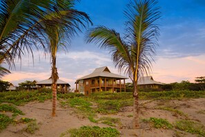 A beachfront property with multiple buildings, including a prominent two-story structure with a balcony. - Indura Beach & Golf Resort, Curio Collection (Tela)