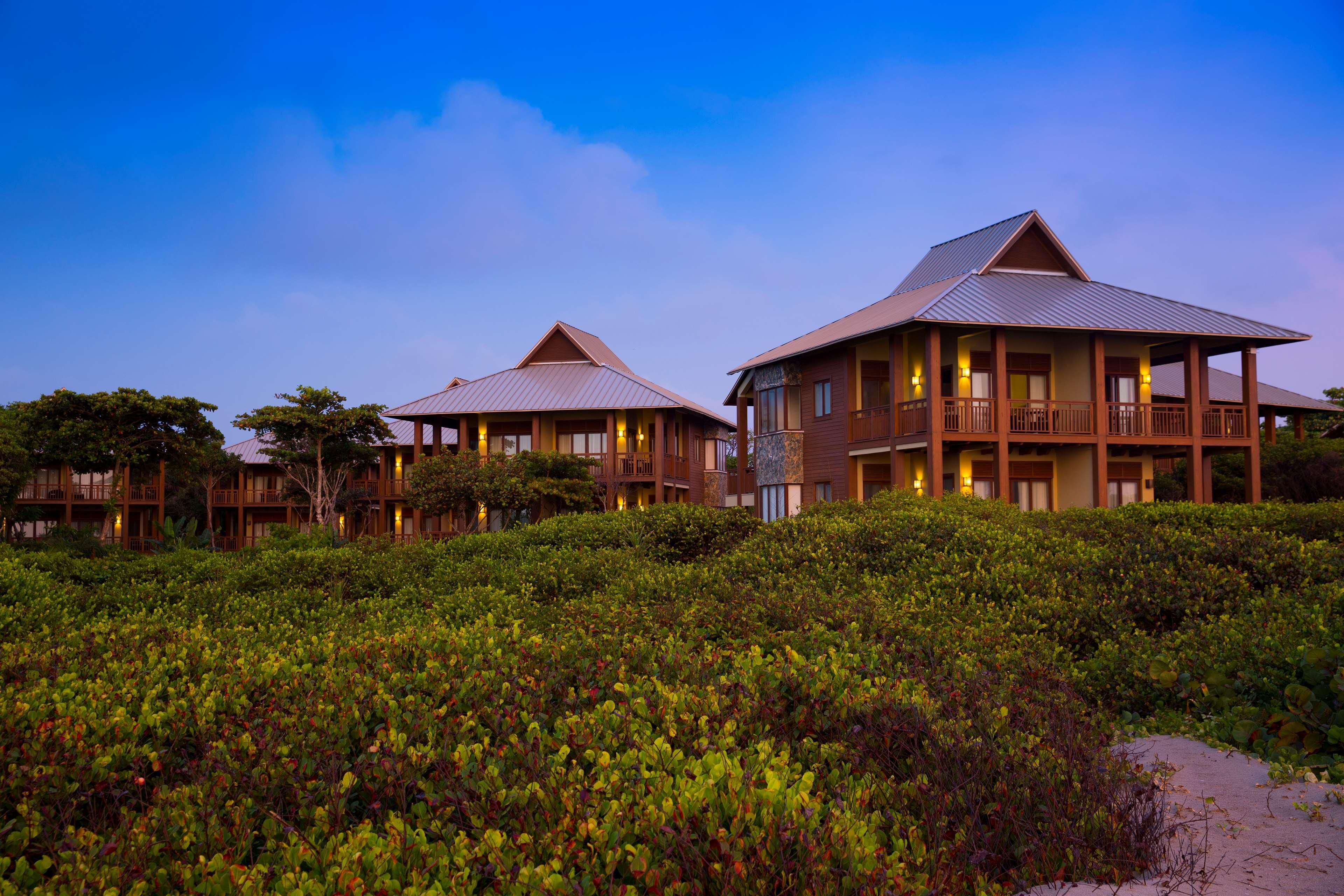 A resort with multiple buildings, each featuring a balcony and a view of the surrounding landscape.