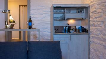 A compact living space with a kitchenette, a sofa, and a dining area.