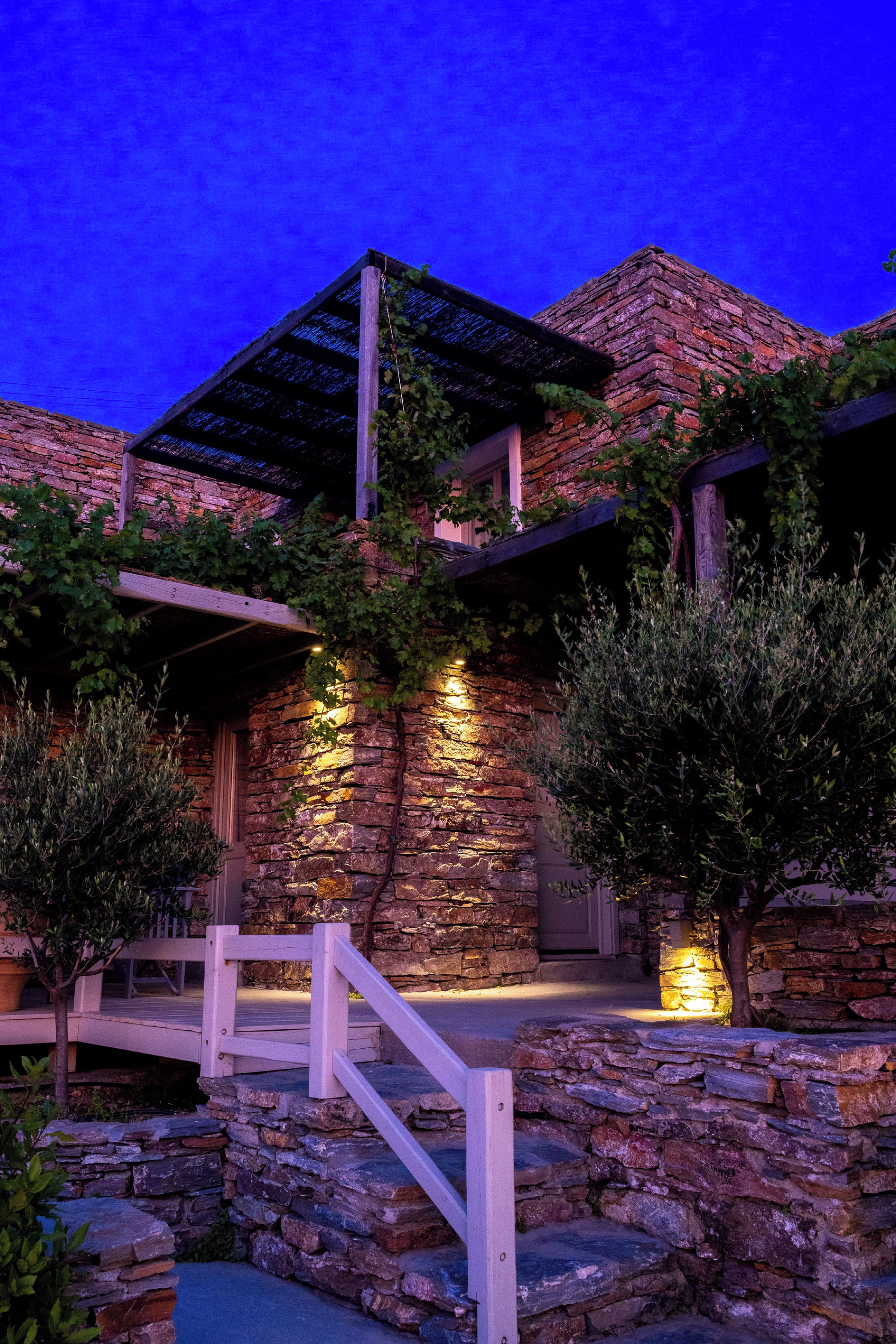 A stone building with a wooden deck and a white railing.
