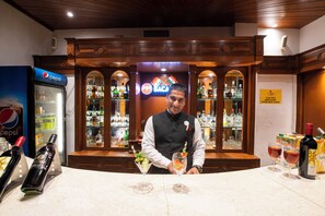 A bar area with a Pepsi refrigerator, a Baca sign, and a bartender. - Citrus Manali Resorts (Manali)
