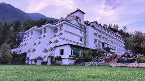A multi-story hotel with a modern architectural design, featuring balconies and a landscaped garden. - Citrus Manali Resorts (Manali)
