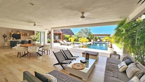 Ein großzügiger Wohnbereich mit Pool, modernen Möbeln und Blick auf den Pool.