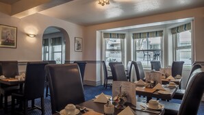 A restaurant with tables set for dining, featuring a menu, cutlery, and napkins. - The Devonshire Park Hotel (Eastbourne)