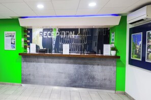 A reception desk with a green wall and a blue accent wall.