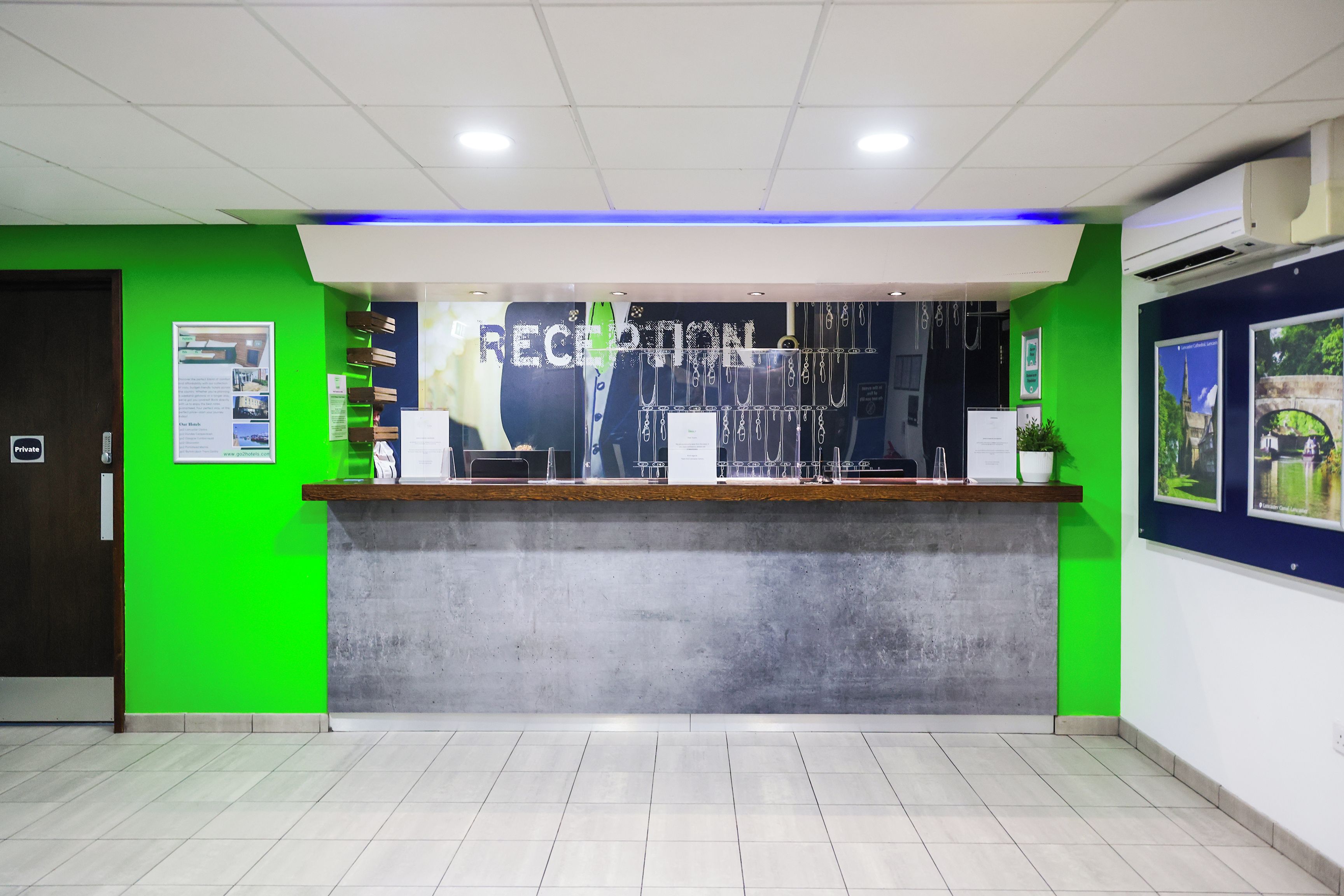 A reception area with a green wall, a reception desk, and a blue accent wall.