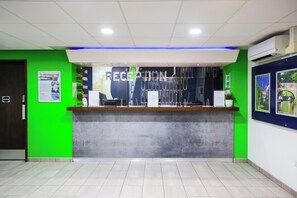 A reception area with a green wall, a reception desk, and a blue accent wall.