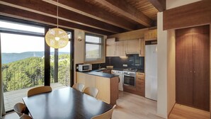 Una cocina moderna con comedor, ventanas amplias y vistas al exterior.