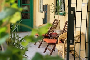 Ein Patio mit Korbmöbeln und einer grünen Tür.