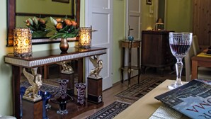 A well-lit room with a wooden console table, decorative glassware, and a framed picture. - Theaterland Classic Apartments (Budapest)