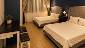 Une chambre d’hôtel avec deux lits, un bureau et une chaise.