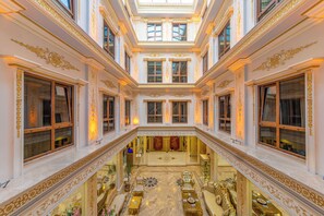 A grand interior with a central open space, ornate columns, and a reflective floor. - Harmony Hotel (Istanbul)