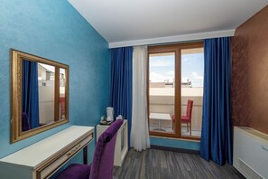 A hotel room with a large window, a desk, a chair, and a radiator. - Harmony Hotel (Istanbul)