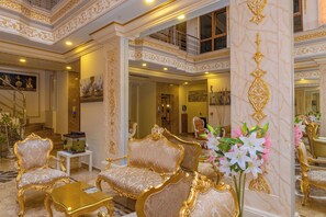 A luxurious interior with ornate gold detailing, plush seating, and a decorative fish tank. - Harmony Hotel (Istanbul)