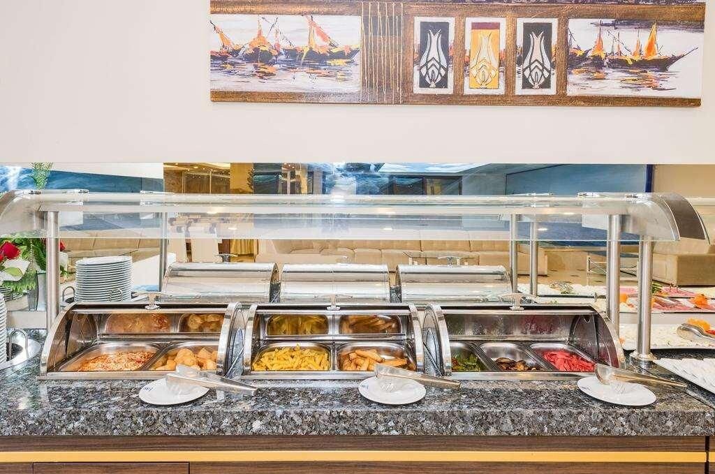 Un buffet con diverse opzioni gastronomiche, una vetrina e una parete con opere d'arte incorniciate.
