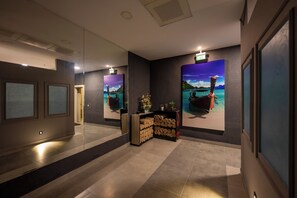 A hallway with a reception desk, framed artwork, and a mirror. - Harmony Hotel (Istanbul)