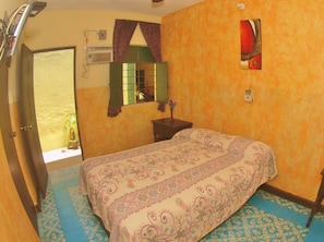 Une chambre à coucher avec un lit, une fenêtre, un miroir et une porte.
