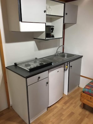 A compact kitchenette with a gas stove, sink, and cabinets. - Orbitur Viana Do Castelo (Viana do Castelo)