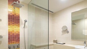 A modern bathroom with a glass shower enclosure, a toilet, a sink, and a mirror. - Sama-sama Express Klia 2 (Sepang)