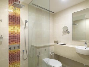 A bathroom with a shower, toilet, sink, and mirror. - Sama-sama Express Klia 2 (Sepang)