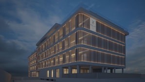 A modern hotel building with a prominent logo, multiple floors, and a distinctive facade design. - Hotel Olbia (Olbia)