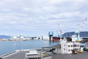 Ein Hafen mit Industriegebäuden, Kränen und einem großen Schiff, das dort liegt.