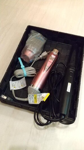 Uma capa preta que contém um dispositivo, um cabo USB, um adaptador de energia e um cabo de carregamento.