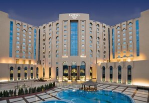 A hotel with a large central pool, multiple floors, and a prominent entrance. - Gewan Hotel Cairo (Giza)