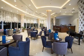 A spacious lobby with a reception desk, a grand piano, and comfortable seating areas. - Gewan Hotel Cairo (Giza)