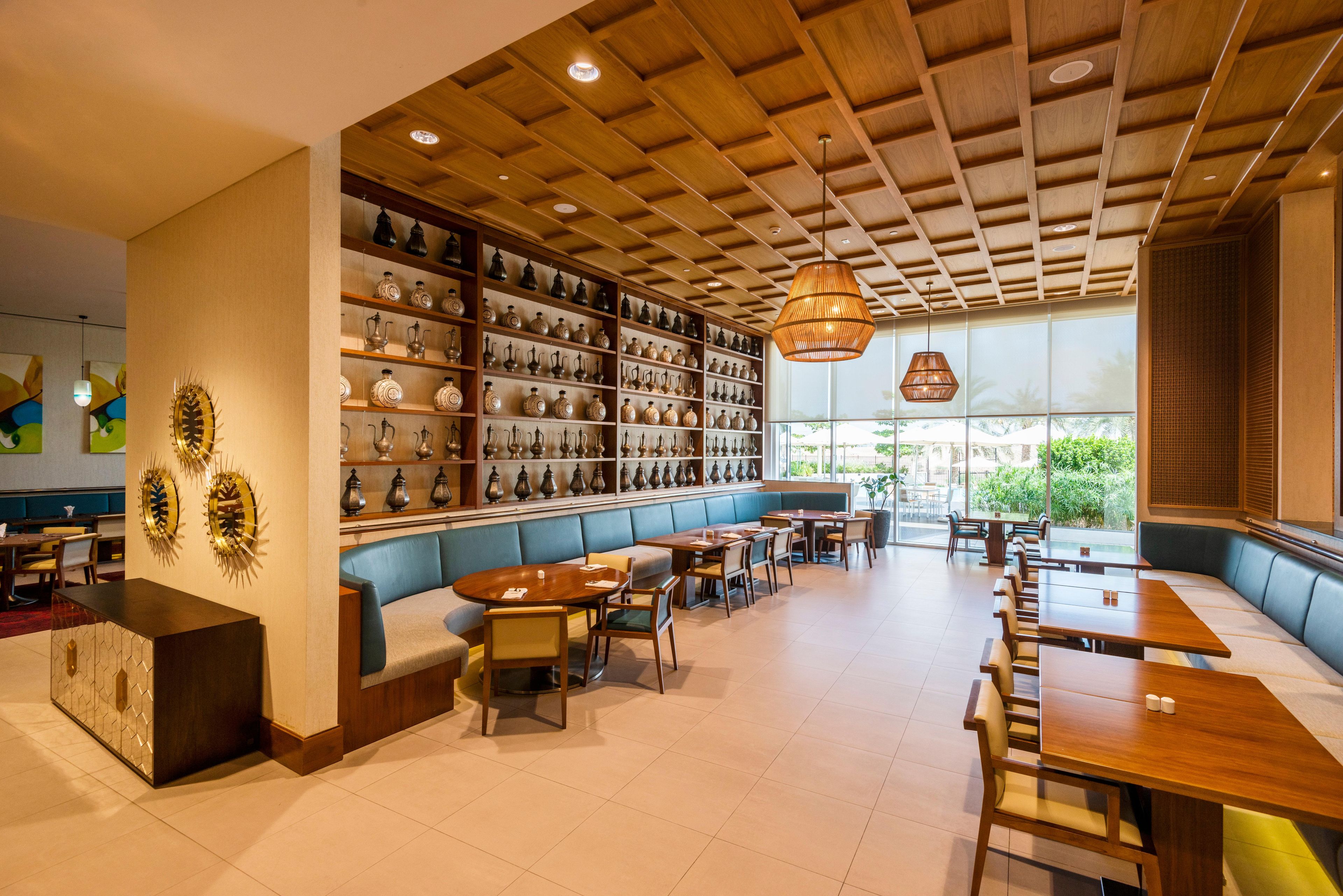 Un restaurante con techo de madera, estantes de cerámica y zonas de estar.