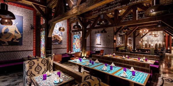 A restaurant with wooden beams, patterned walls, and tables set for dining. - Crowne Plaza Muscat Ocec (Muscat)