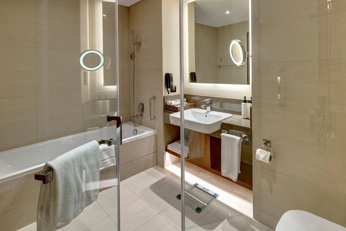 A modern bathroom with a glass-enclosed shower, a separate sink, and a toilet.