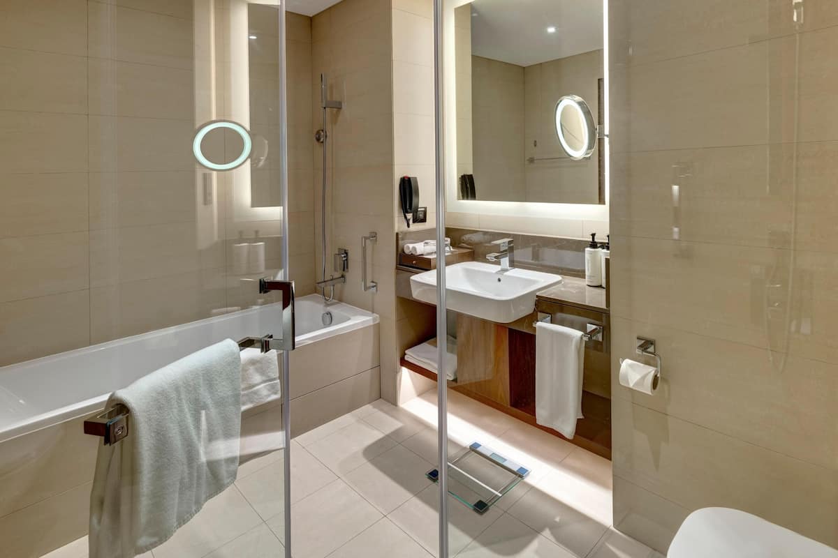 Un baño moderno con cabina de ducha de vidrio, lavamanos separado y un inodoro.