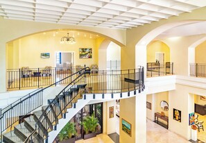 A spacious interior with a central staircase, multiple seating areas, and artwork on the walls. - Jewel Grande Montego Bay Resort&spa (Montego Bay)