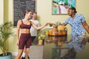 A reception area with a glass counter, a potted plant, and a chalkboard menu listing various food and drink items. - Jewel Grande Montego Bay Resort&spa (Montego Bay)