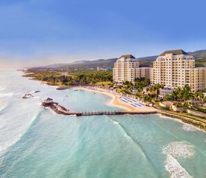 Ein Küstenhotel mit mehreren Gebäuden, einem Strand und einer Pier.