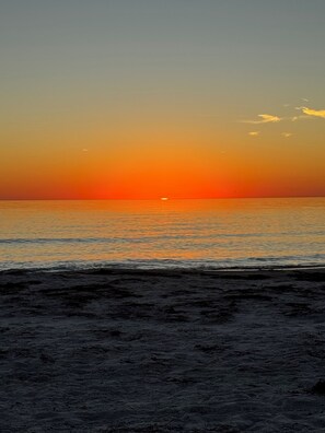 Ein Strand bei Sonnenuntergang über dem Meer.