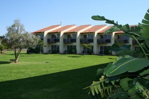A multi-story building with a consistent roofline, balconies, and a well-maintained lawn. - Pastoral Hotel (HaGalil HaElyon)