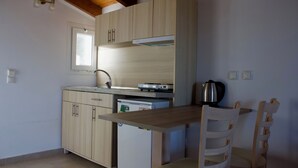 Una cocina compacta con armarios de madera, lavavajillas integrado y un refrigerador pequeño.