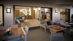 Ein modernes Wohnzimmer mit einer Couch, Sesseln, einem Esstisch und einer Küche im Hintergrund.