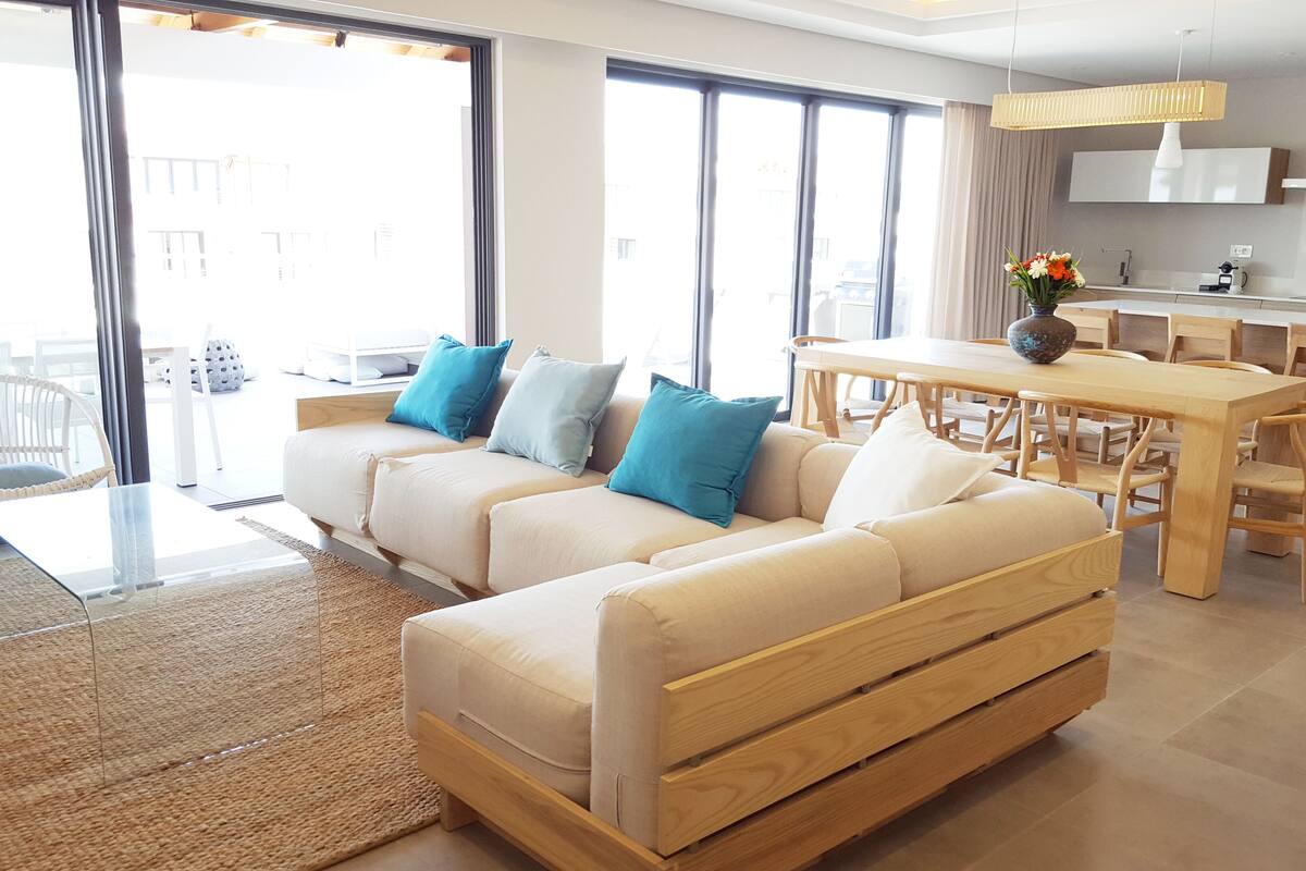 Una sala de estar moderna con un sofá, una mesa de comedor y sillas.