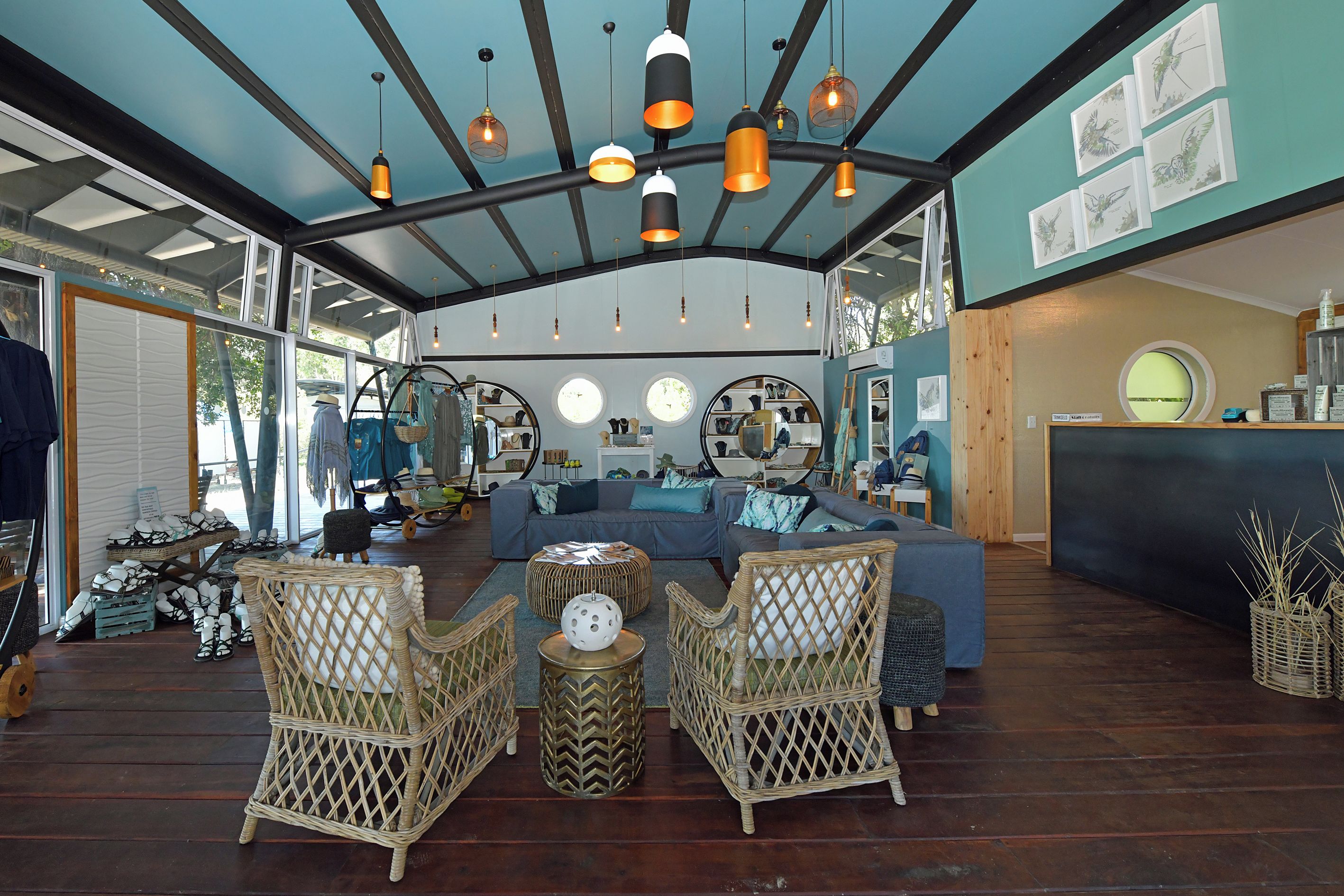 Una habitación amplia con techo azul, muebles de mimbre y una mesa redonda.