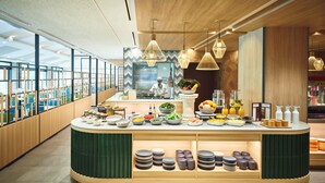 Una moderna presentación de buffet, con un chef preparando alimentos, una variedad de platos y platos ordenados.
