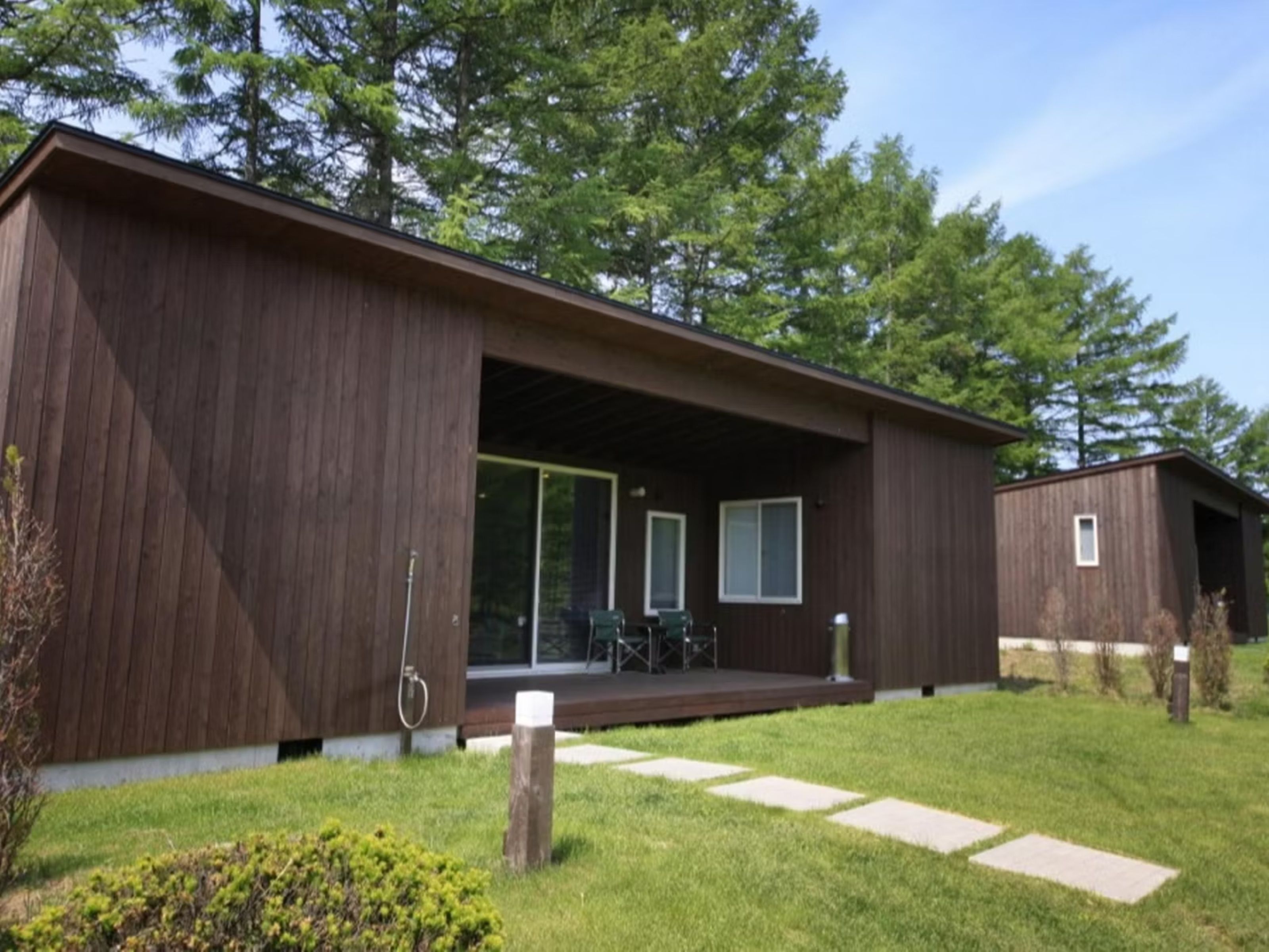 A modern building with a covered outdoor area, a visible door, and a small window.
