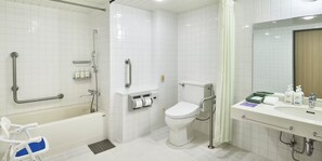 A modern bathroom with a bathtub, toilet, and shower area, equipped with grab bars and a hand dryer. - ANA Holiday Inn Resort Karuizawa by IHG (Naganohara)