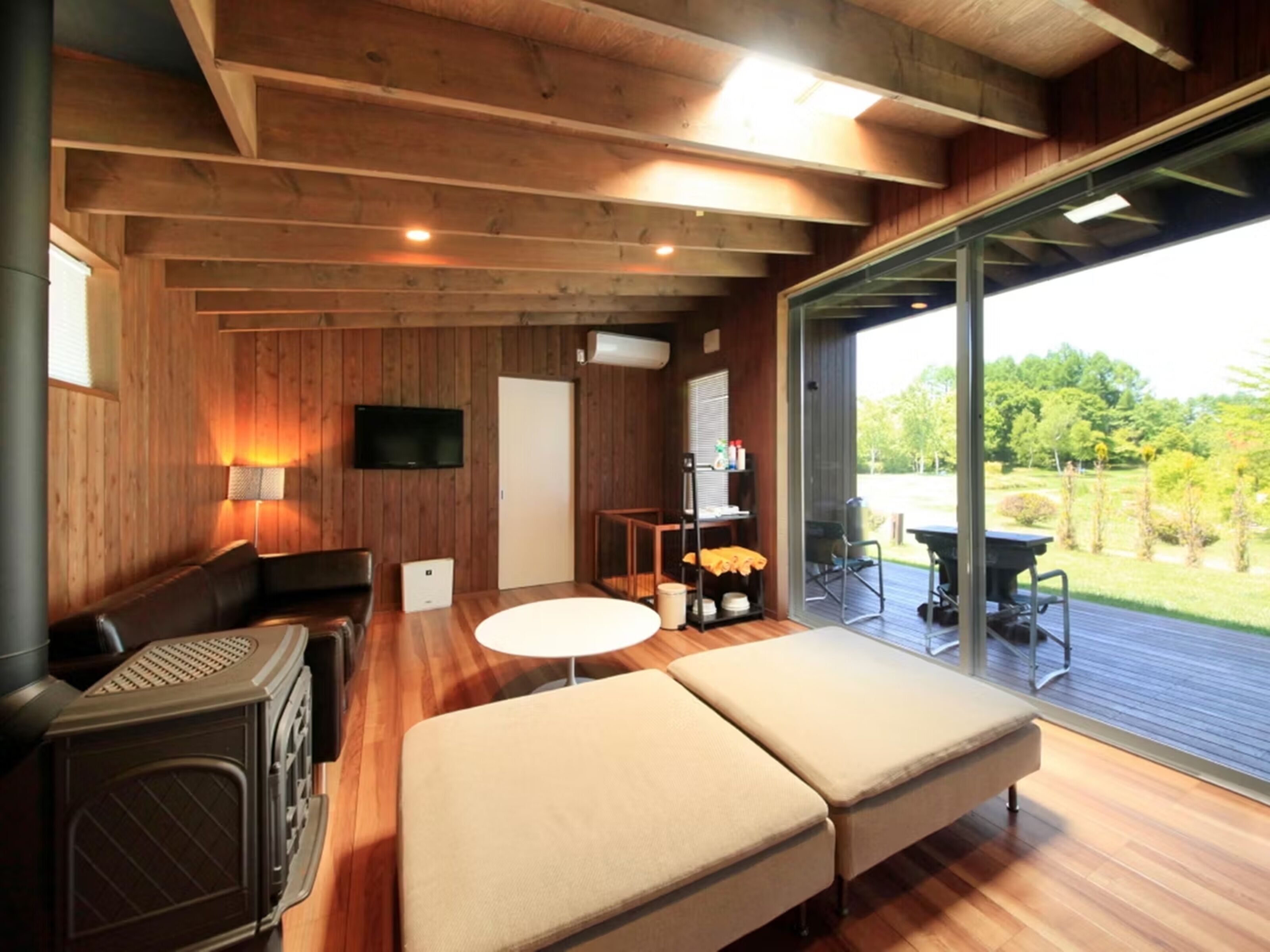 Ein modernes Interieur mit Holzwänden, einer Couch, einem Tisch und einem Fernseher.