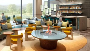 Un área de descanso moderna con una chimenea central, disposiciones de asientos y un bar con estantes llenos de botellas.
