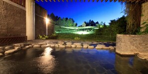 A stone pathway leading to a water feature with a brick wall on one side and a wooden pergola overhead. - ANA Holiday Inn Resort Karuizawa by IHG (Naganohara)