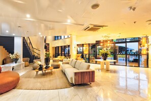 Eine großzügige Lobby mit einem modernen Sofa, einem Couchtisch und einer Treppe.