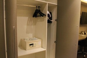 A hotel room with a minibar, a coat rack, and a desk with a computer and a telephone. - Holiday Inn Goiania (Goiânia)